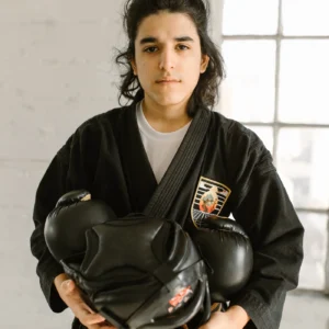 Martial artist holding black chest and rib protective gear