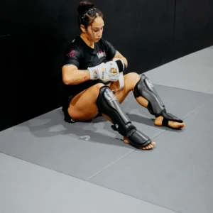 Martial artist putting on protective elbow pads
