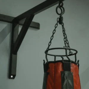 Red heavy punching bag hanging in a gym