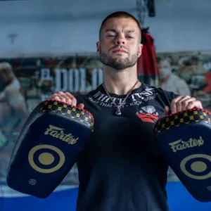 Coach wearing curved Muay Thai focus pads